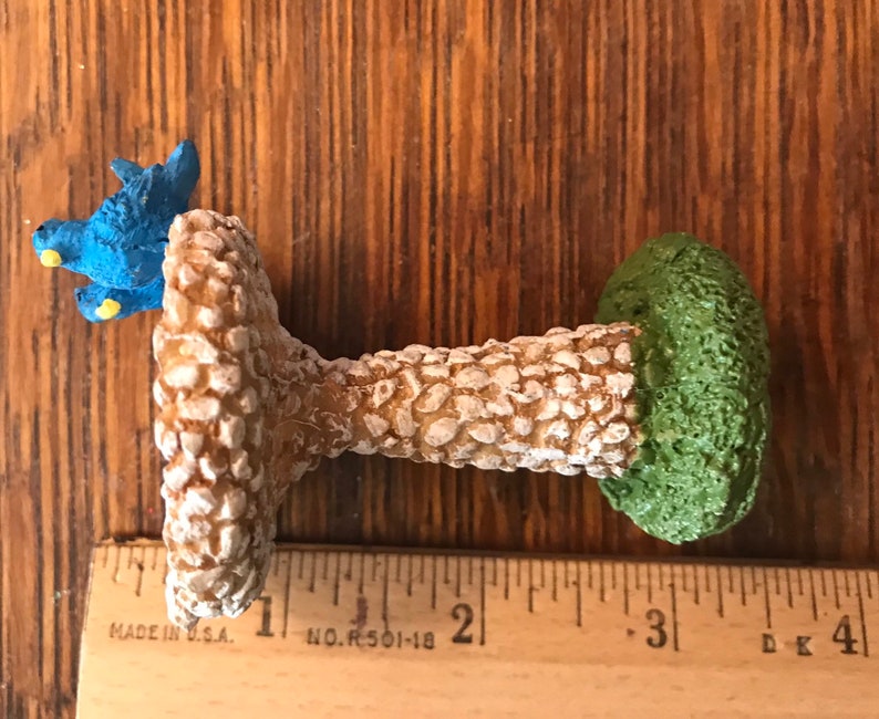 K&ouml;nnte beinhalten: Ein Miniatur-Vogelbad mit zwei blauen V&ouml;geln, die auf dem Rand sitzen. Das Bad ist aus einem strukturierten Material, das Stein &auml;hnelt, und hat eine gr&uuml;ne Basis.