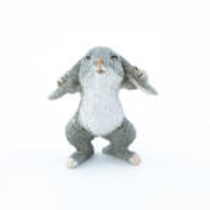 May include: A gray and white rabbit figurine with large ears, standing on its hind legs with its front paws raised.