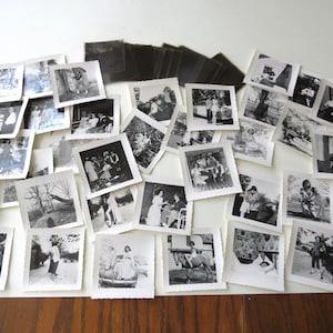 May include: A white ceramic mug with a black handle and the text "But First, Coffee" in a bold, black font. The mug is set against a blurred background, suggesting a cozy setting.