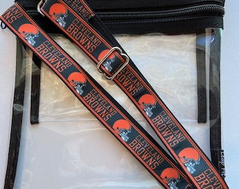 May include: Clear plastic bag with a black zippered top and two adjustable straps. The straps are black with a white background and feature the Cleveland Browns logo and the words "Cleveland Browns" repeated.
