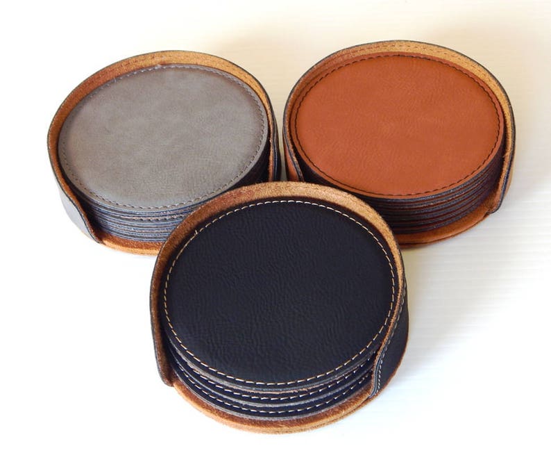May include: Set of six leather coasters in gray, brown, and black. Each coaster has a stitched edge and is stacked on top of each other.