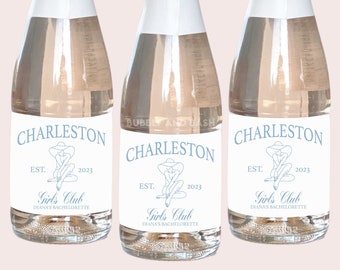 May include: Three mini champagne bottles with labels that say "Charleston Est. 2023 Girls Club Diana's Bachelorette".