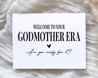 May include: White card with black text that says "Welcome to your Godmother Era. Are you ready for it?" with a small black heart in the middle.