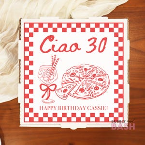 May include: A white pizza box with a red checkered border and red text that says "Ciao 30" and "Happy Birthday Cassie!". The box features a pizza graphic, a cocktail, and a bow.
