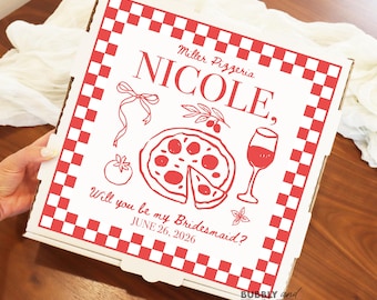 May include: A white pizza box with a red checkered border and red illustrations of pizza, a wine glass, and other graphics. The text "Miller Pizzeria, NICOLE, Will you be my Bridesmaid? JUNE 26, 2026" is printed on the box.