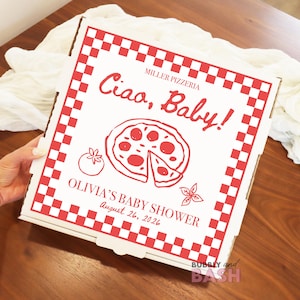 May include: A white pizza box with a red checkered border and red text. The text reads "Ciao, Baby!" and "OLIVIA'S BABY SHOWER August 26, 2026." A pizza illustration is in the center.