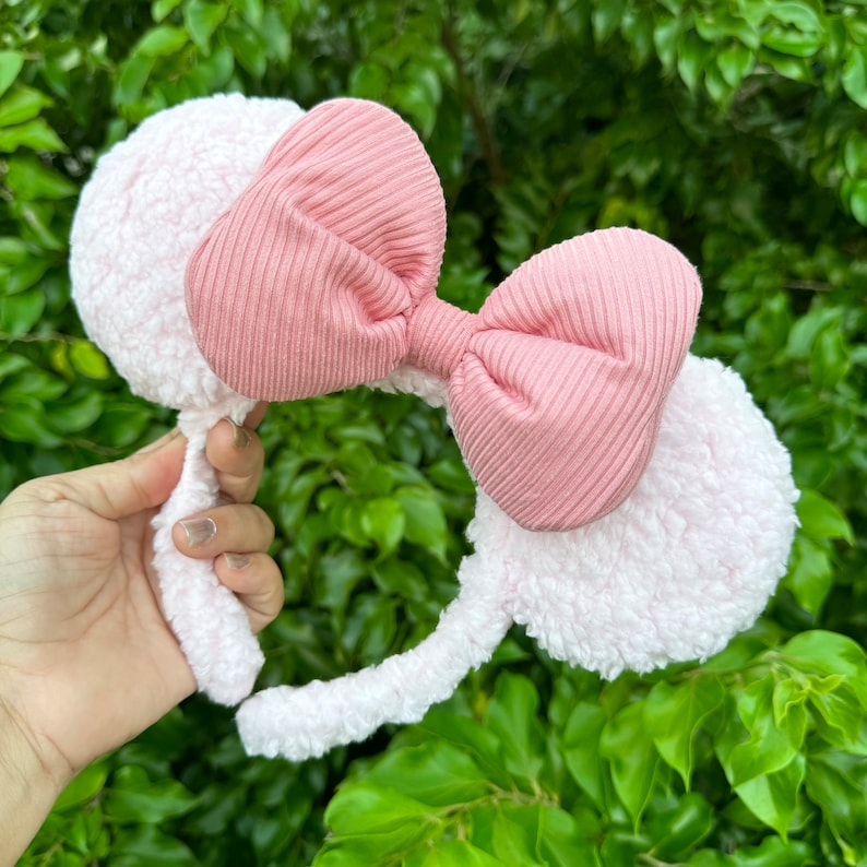 Pode incluir: Faixa de cabelo rosa peluda com um grande la&ccedil;o rosa. A faixa de cabelo &eacute; feita de um material macio e felpudo e o la&ccedil;o &eacute; feito de um tecido canelado.