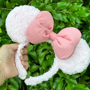 Pode incluir: Faixa de cabelo rosa peluda com um grande la&ccedil;o rosa. A faixa de cabelo &eacute; feita de um material macio e felpudo e o la&ccedil;o &eacute; feito de um tecido canelado.