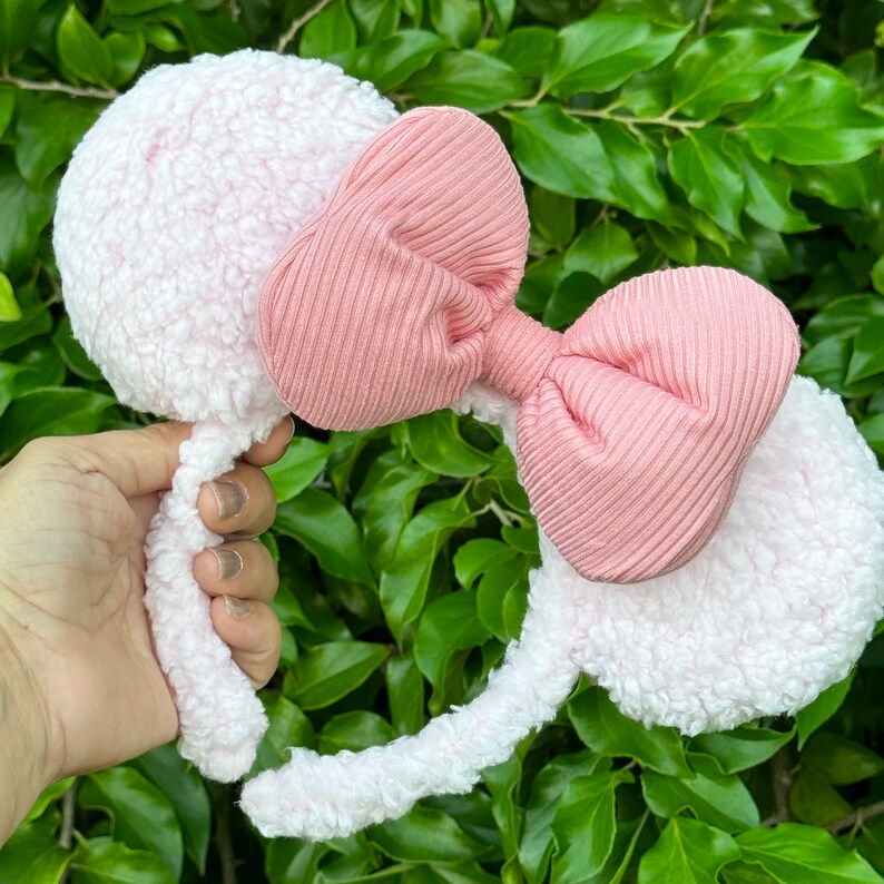 Pode incluir: Faixa de cabelo rosa peluda com um grande la&ccedil;o rosa. A faixa de cabelo &eacute; feita de um material macio e felpudo e o la&ccedil;o &eacute; feito de um tecido canelado.
