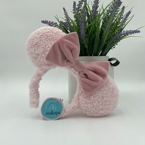 May include: Pink fluffy mouse ear headband with a pink velvet bow. The headband has a blue tag that says "Handmade Ah AntikaPR".