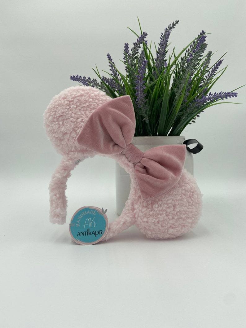 May include: Pink fluffy mouse ear headband with a pink velvet bow. The headband has a blue tag that says "Handmade Ah AntikaPR".