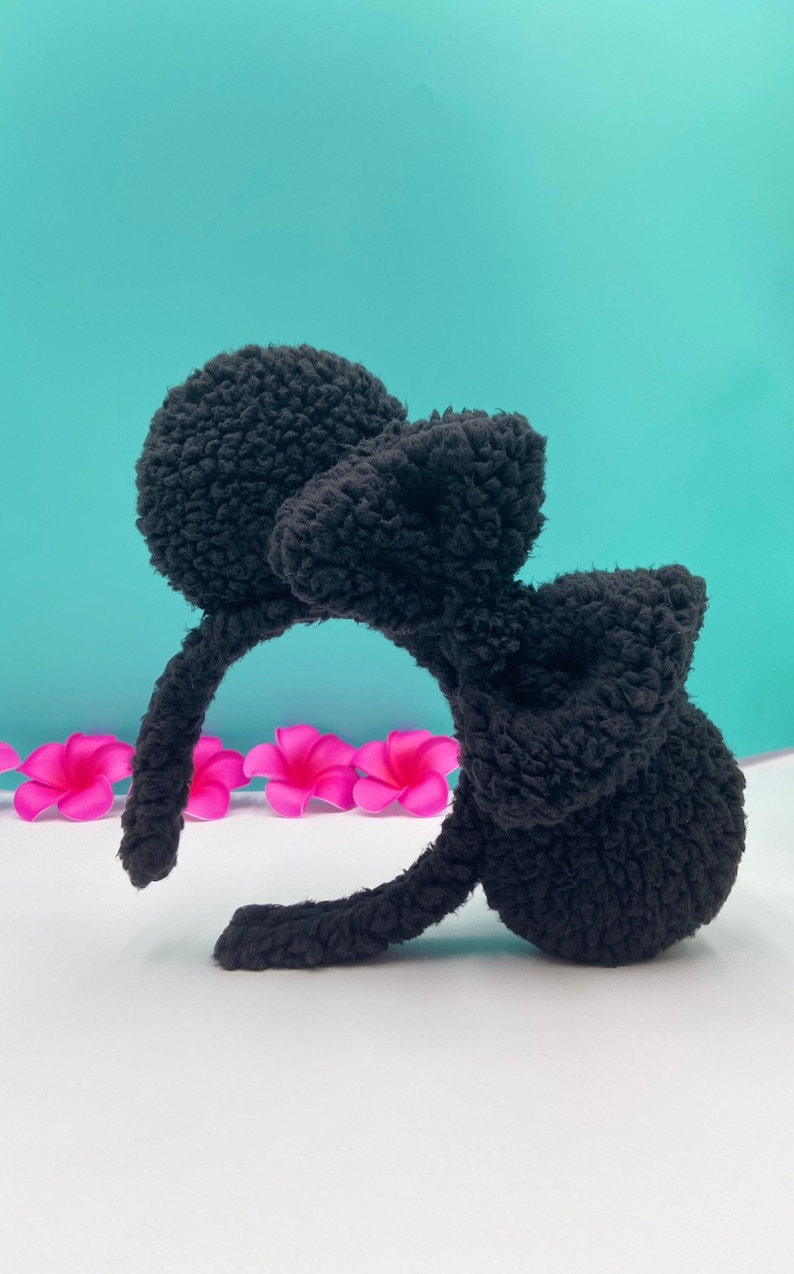May include: Black fuzzy headband with large bow and two fluffy ear-like accents.