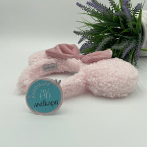 May include: Pink fluffy bunny ear headband with a pink satin bow. The headband has a handmade tag with the text "Ak Antikapr" on it.