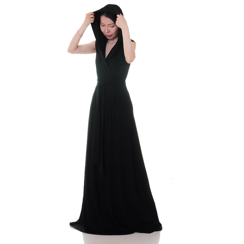 May include: A long, black maxi dress with a hood and a wrap-style bodice. The dress is sleeveless and has a tie at the waist.
