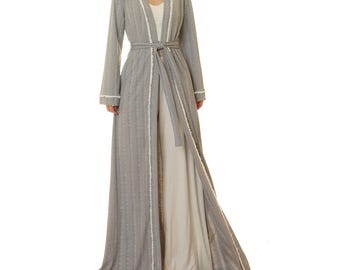 May include: A long gray robe with white trim and a tie belt. The robe is made of a soft, comfortable fabric and has a relaxed fit.