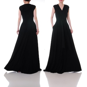 May include: A black maxi dress with a V-neckline and a hood. The dress has a tie belt and pockets.
