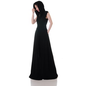 May include: A black maxi dress with a long, flowing skirt and a hood. The dress has a wrap-style bodice and a tie belt at the waist.