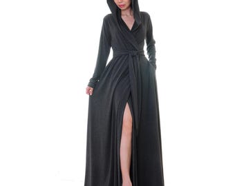 May include: A long, charcoal gray wrap dress with a hood and a side slit. The dress has a tie belt at the waist and pockets on the sides.