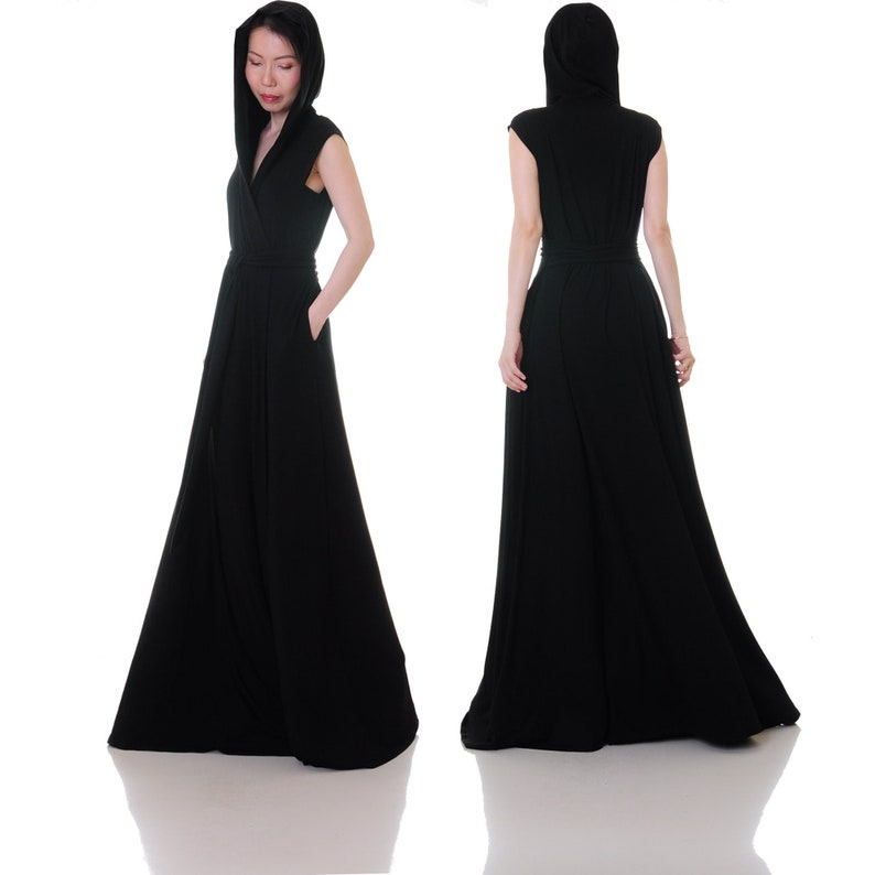 May include: A black maxi dress with a hood and sleeveless design. The dress has a wrap-style neckline and a flowing skirt.