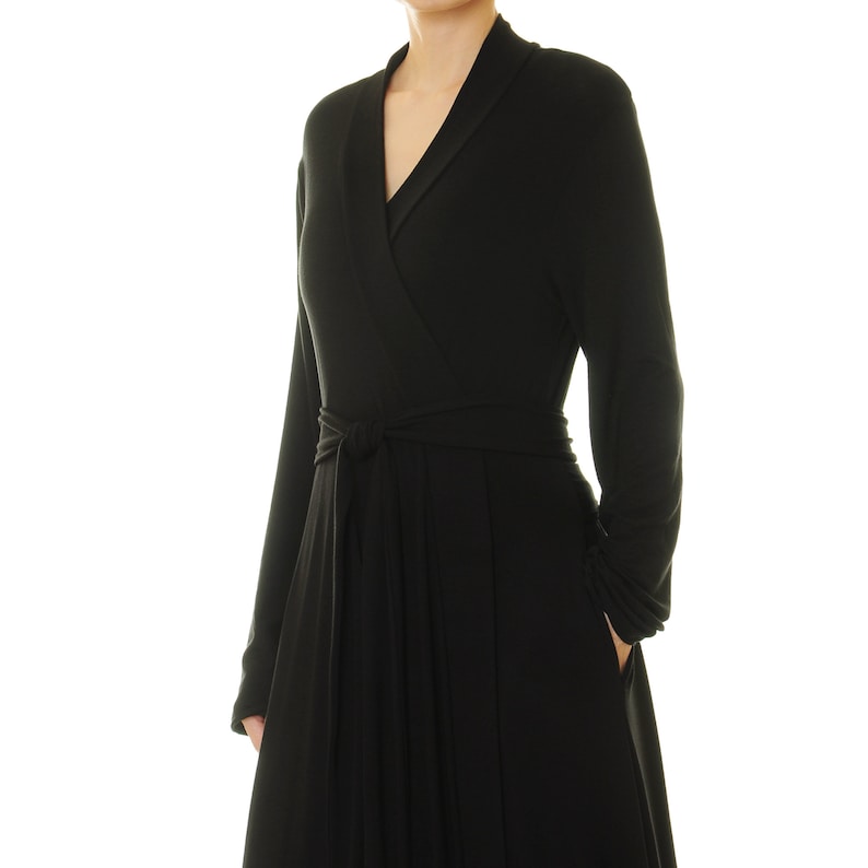 K&ouml;nnte beinhalten: Ein schwarzes Wickelkleid mit langen &Auml;rmeln und einem Bindeg&uuml;rtel.
