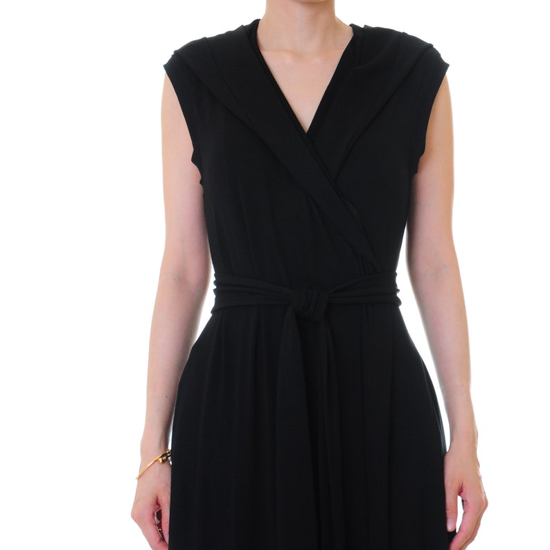 May include: A black sleeveless wrap dress with a V-neckline and a self-tie belt.
