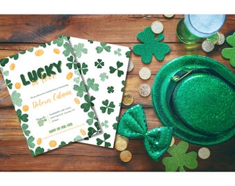 May include: A white invitation card with green shamrocks and gold coins. The text on the card reads "Lucky in Love" and includes the details for a "St. Patrick's Day Dinner Party" for Delores Catania. The invitation is on a wooden table with a green shamrock hat, gold coins, and a green bow.