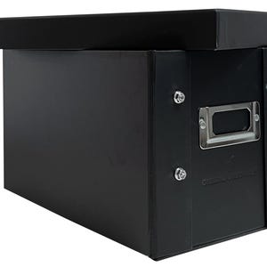 May include: Black storage box with a hinged lid and a label holder. The box has metal accents and is made of sturdy cardboard.