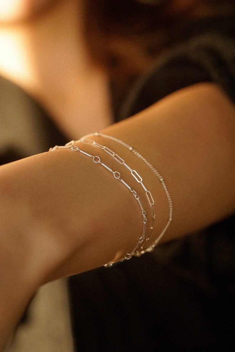 Three-piece bracelet set with a sterling silver bar bracelet, a 2mm paperclip bracelet, and a thin satellite bracelet.