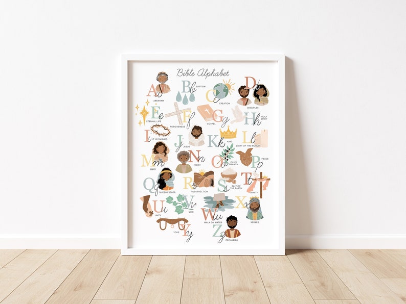 May include: A framed print featuring the "Bible Alphabet" with illustrations for each letter. The artwork includes images of people, religious symbols, and words like "Abraham," "Baptism," and "Disciples." The color palette is soft, with pastel hues and a white frame.