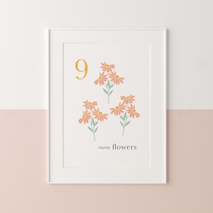 May include: A white framed print with a yellow number 9 and nine pink flowers with green stems. The text "nine flowers" is below the flowers.