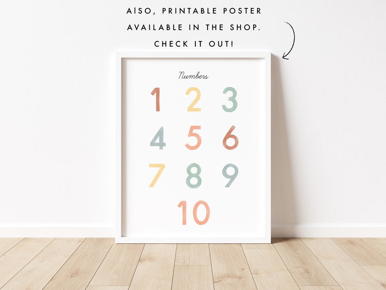 May include: A printable poster with the numbers 1 through 10 in a colorful, pastel color scheme. The numbers are arranged in a grid pattern. The poster is framed in a white frame and is hanging on a white wall.