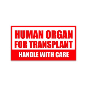 May include: A rectangular red and white sign with the text "HUMAN ORGAN FOR TRANSPLANT HANDLE WITH CARE" in bold, capital letters. The text is in white, set against a red background.