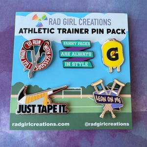 May include: Athletic trainer pin pack featuring six enamel pins. Pins include scissors, a Gatorade bottle, crutches, and a Nike-inspired design with the text "Just Tape It." Other pins read "Fanny Packs Are Always In Style."