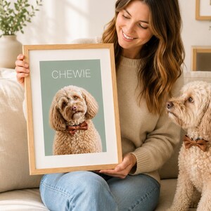 May include: A framed portrait print featuring a light brown curly-haired dog wearing a brown bow tie against a sage green background with the name CHEWIE printed in white capital letters at the top of the image inside the frame.