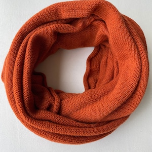 May include: A warm orange knitted infinity scarf. The scarf is made of a soft, cozy material and is perfect for keeping warm in the winter.
