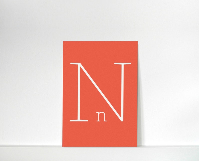 Puede incluir: Una tarjeta de color rojo coral con una letra N blanca en una fuente simple y moderna. La letra N est&aacute; centrada en la tarjeta. La letra n tambi&eacute;n est&aacute; escrita en blanco debajo de la letra N.