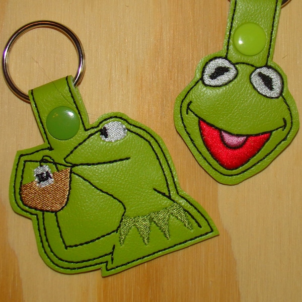 Green frog head and green frog drinking tea, beloved kid's character vinyl key fobs! None of my business...  Kermit