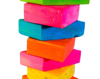 May include: A stack of colorful wooden blocks in various shades of green, purple, pink, blue, orange, yellow, and red. The blocks are stacked on top of each other, creating a rainbow effect.