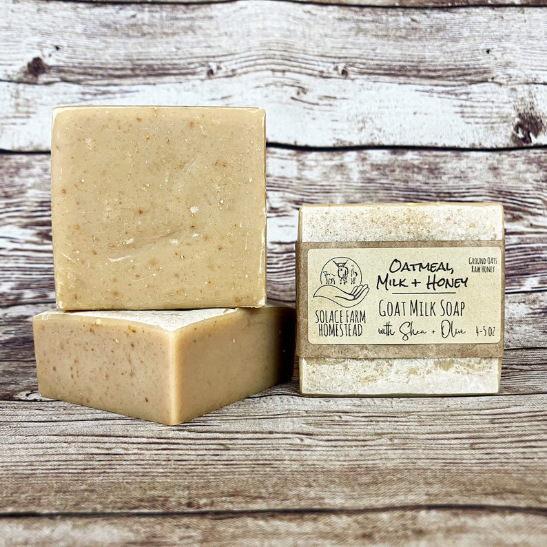 K&ouml;nnte beinhalten: Drei St&uuml;ck Ziegenmilchseife &uuml;bereinander gestapelt. Die oberste Seife hat ein Etikett mit der Aufschrift "Oatmeal, Milk + Honey Goat Milk Soap with Shea + Olive 4-5 oz. Ground Oats Raw Honey Solace Farm Homestead".