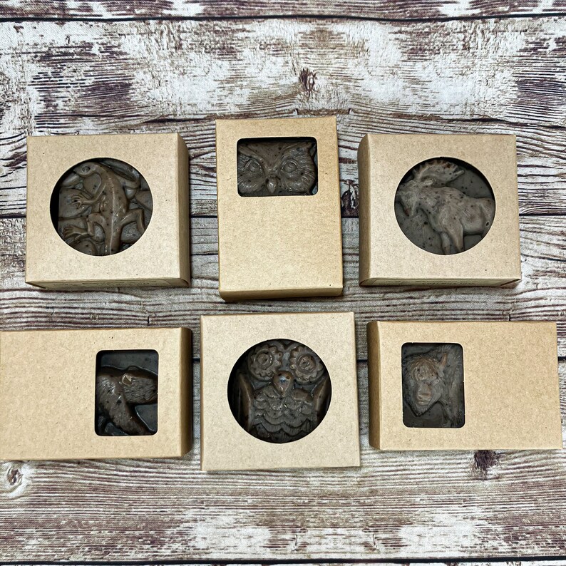 Puede incluir: Seis cajas de cart&oacute;n marr&oacute;n con ventanas de pl&aacute;stico transparente, cada una con un dise&ntilde;o de animal diferente. Los animales incluyen un b&uacute;ho, un alce, un oso y una ardilla. Las cajas est&aacute;n dispuestas en dos filas de tres.