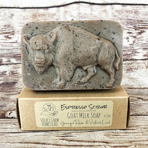 Puede incluir: Una barra de jab&oacute;n de leche de cabra marr&oacute;n con un dise&ntilde;o de b&uacute;falo. El jab&oacute;n est&aacute; etiquetado como "Espresso Scrub Goat Milk Soap 4.5 oz. Grassfed Tallow & Pastured Lard" y "Solace Farm Homestead".