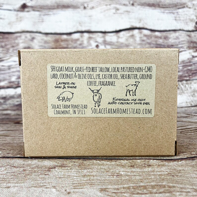 Puede incluir: Una caja de cart&oacute;n marr&oacute;n con una etiqueta blanca. La etiqueta enumera los ingredientes de una pastilla de jab&oacute;n de leche de cabra, que incluyen leche de cabra, sebo de res alimentado con pasto, manteca de cerdo no modificada gen&eacute;ticamente de pastoreo local, aceites de coco y oliva, lej&iacute;a, aceite de ricino, manteca de karit&eacute;, caf&eacute; molido y fragancia. La etiqueta tambi&eacute;n incluye el texto "Lather on Skin & Rinse" y "External Use Only Avoid Contact With Eyes". La etiqueta incluye el nombre de la empresa "Solace Farm Homestead" y la direcci&oacute;n del sitio web "solacefarmhomestead.com".