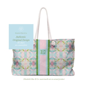 Peut inclure: Un sac fourre-tout avec un motif aquarelle pastel dans des tons de rose, bleu et vert. Le sac pr&eacute;sente une bande verticale centrale rose clair encadr&eacute;e par deux bandes vertes, avec un monogramme E vert. Il poss&egrave;de des anses en corde blanche.