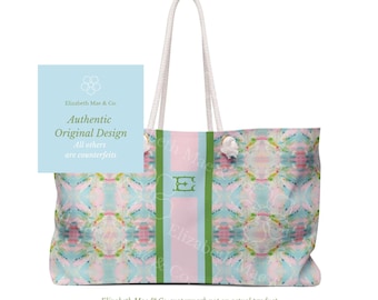 May include: A tote bag featuring a pastel watercolor pattern in shades of pink, blue, and green. The bag has a central vertical stripe in light pink flanked by two green stripes, with a green letter E monogram. It includes white rope handles.