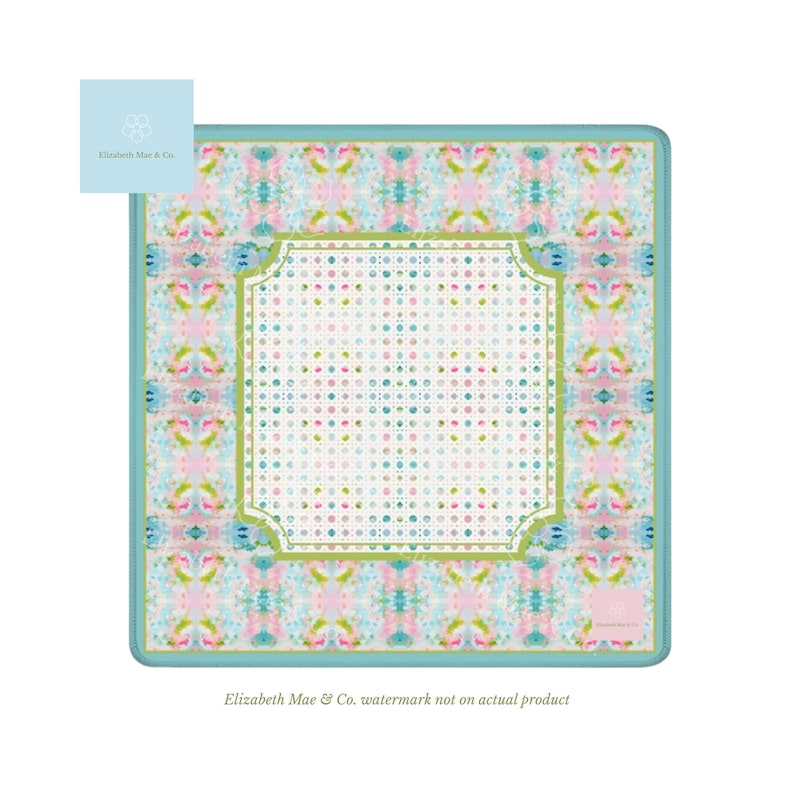 May include: A square textile featuring a central white panel with a grid of small pink, blue, and green dots, framed by a lime green border. The outer section displays a repeating abstract pattern of soft pink, blue, and green watercolor-like shapes.