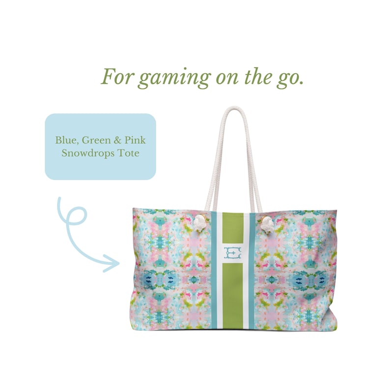 May include: A tote bag featuring a blue, green, and pink abstract floral pattern with a central vertical green stripe and white rope handles. The text "For gaming on the go." appears above, and a box labels it "Blue, Green & Pink Snowdrops Tote".