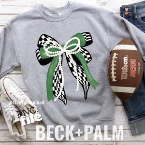May include: A gray sweatshirt featuring a large bow design with green and black checkered ribbons, accented with a string of pearls. A brown football and white sneakers are also visible. The text "BECK+PALM" is at the bottom.