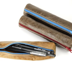Astuccio rotondo in pelle. Astuccio con cerniera.