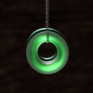 May include: A green glass pendant with a silver chain. The pendant is a double ring with a hollow center.