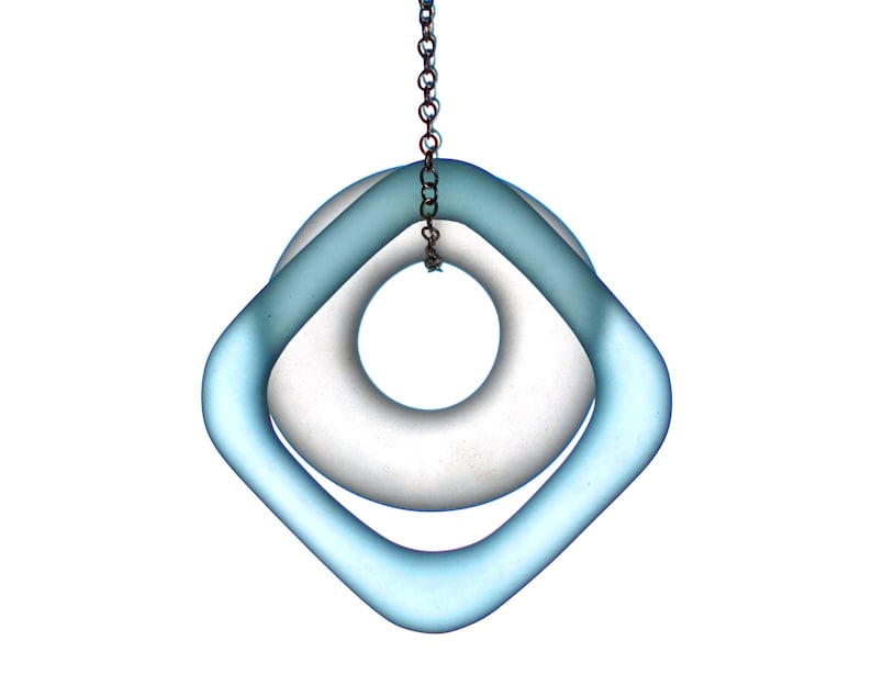 May include: A white ring with a light blue square ring around it, hanging from a silver chain.